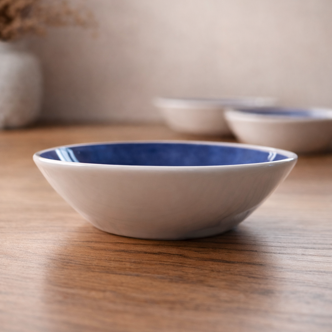 White bowl with blue interior on a wooden surface