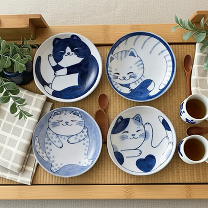 Set of four ceramic plates with cat designs on a wooden tray.