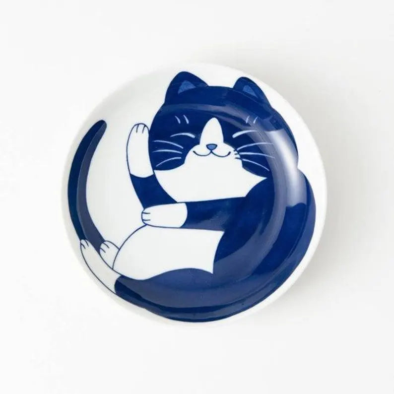 Round ceramic plate with a blue and white cat design on a white background